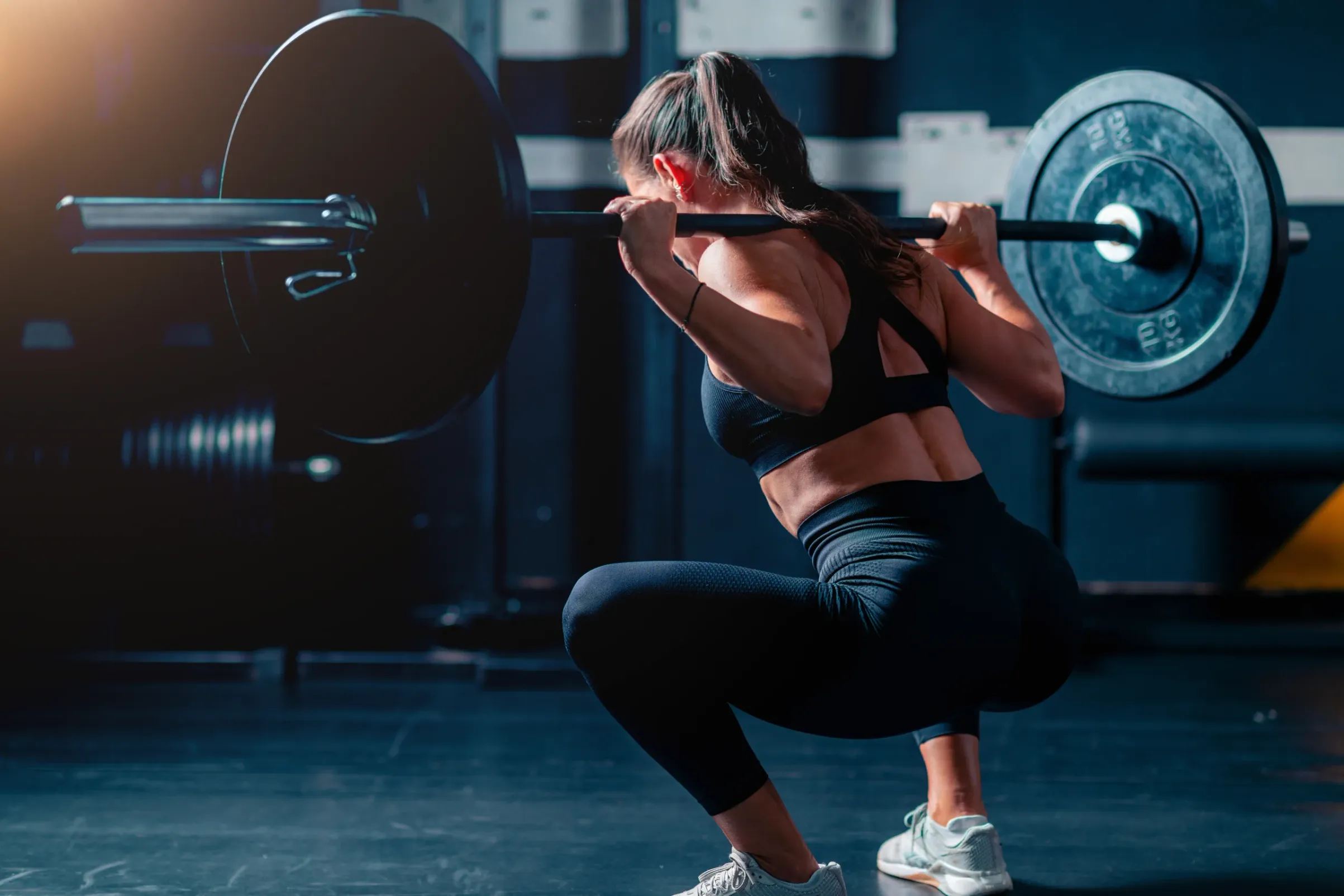 Woman in a deep barbell back squat