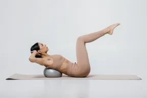 Woman practicing Pilates Essentials with a Pilates ball